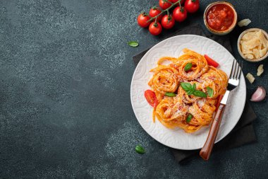 Lezzetli iştah açıcı klasik İtalyan tagliatelle makarnası domates soslu, peynirli parmesan peyniri ve siyah tabakta fesleğen. Yukarıdan bak, yatay. Kopyalama alanı olan üst görünüm