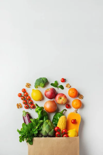Sağlıklı beslenme geçmişi. Kağıt torba içinde sağlıklı vejetaryen yemekleri sebzeler ve beyaz üzerine meyveler, fotokopi alanı, afiş. Alışveriş süpermarketi ve temiz vegan yeme konsepti. — Stok fotoğraf