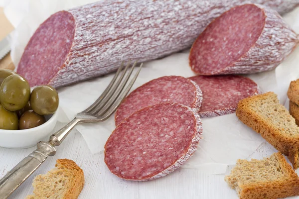 Salami with toasts and olives — Stock Photo, Image