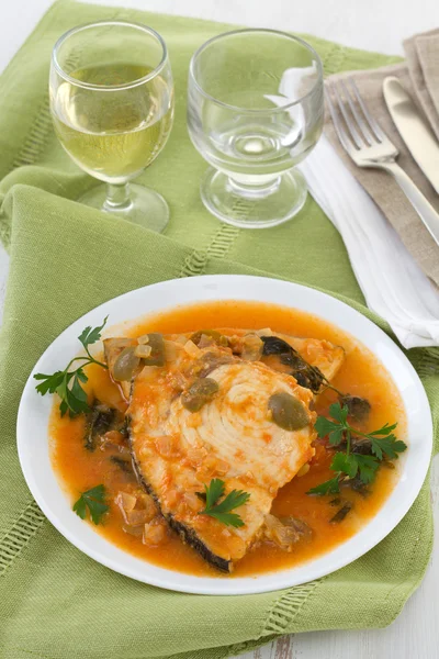 Рыба в соусе на тарелке — стоковое фото