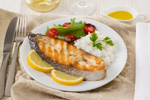 Kızarmış balık, pilav, limon ve salata.
