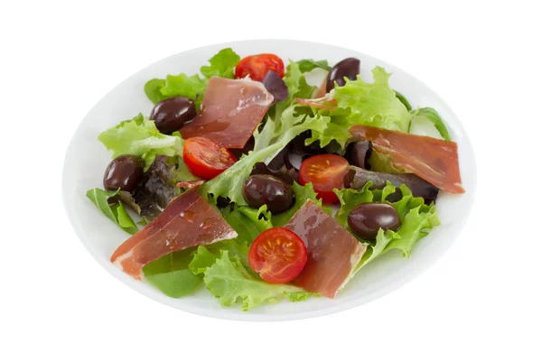 Salad with prosciutto, tomato and olives on the plate — Stock Photo, Image
