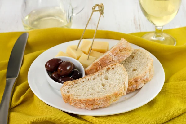 Pane con olive e formaggio nel piatto con vino — Foto Stock
