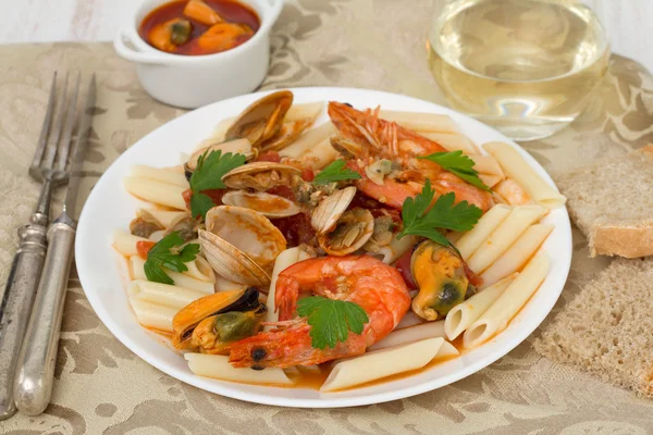 Pâtes avec fruits de mer sur l'assiette et vin blanc — Photo