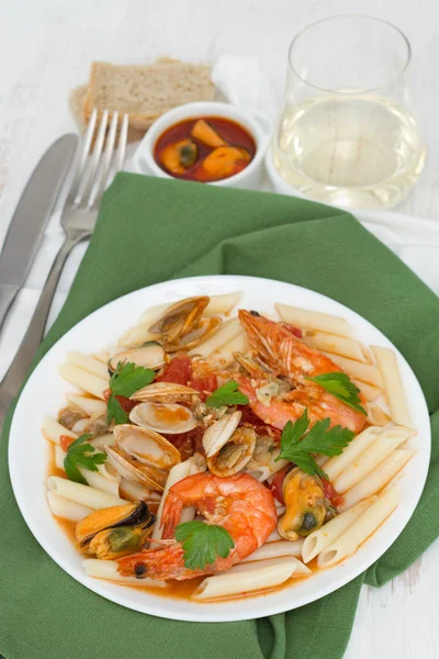 Pasta with seafood on the plate and white wine — Stock Photo, Image