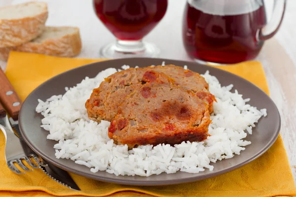 Рулон мяса с вареным рисом на тарелке — стоковое фото