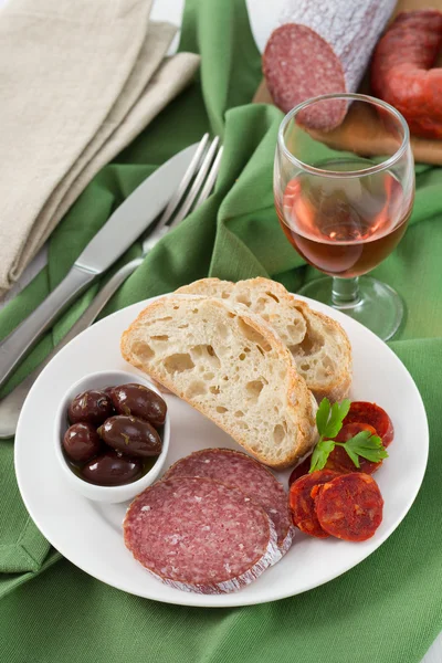 Sausages with olives and bread on the plate — Stock Photo, Image