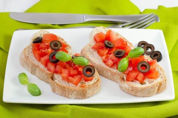 Tostadas con tomate y aceitunas en el plato —  Fotos de Stock