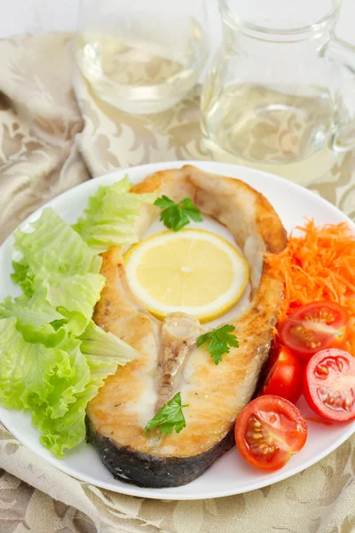 Gebratener Fisch mit Gemüse auf dem weißen Teller — Stockfoto