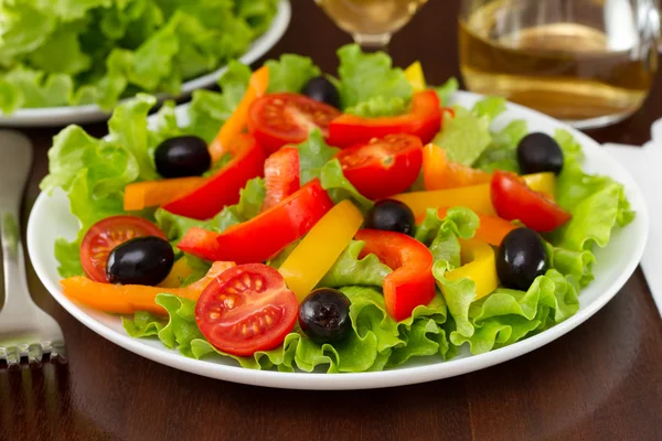 Salad with pepper, olives and lettuce on the plate — Stock Photo, Image