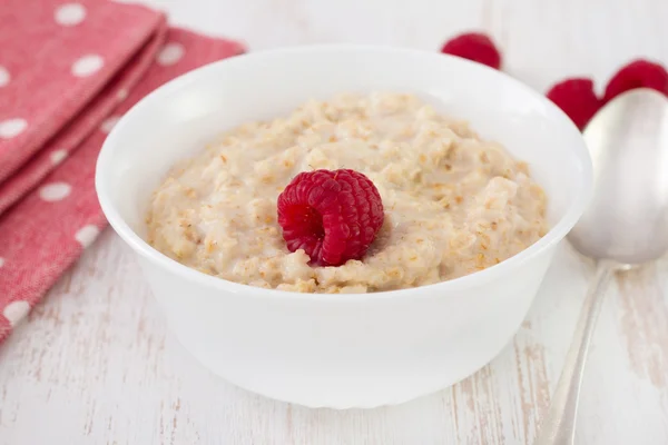 Porridge with raspberry in the white bowl — Stock Photo, Image