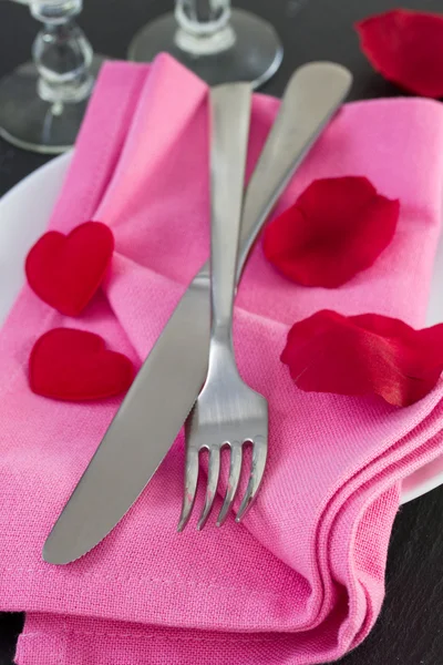 Вилка и нож на розовой салфетке — стоковое фото