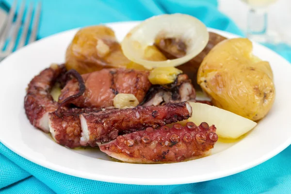 Осьминог с картошкой и маслом на тарелке — стоковое фото
