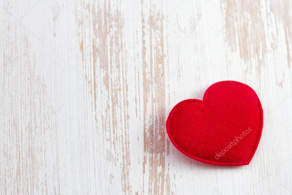 Red heart on old wooden desk