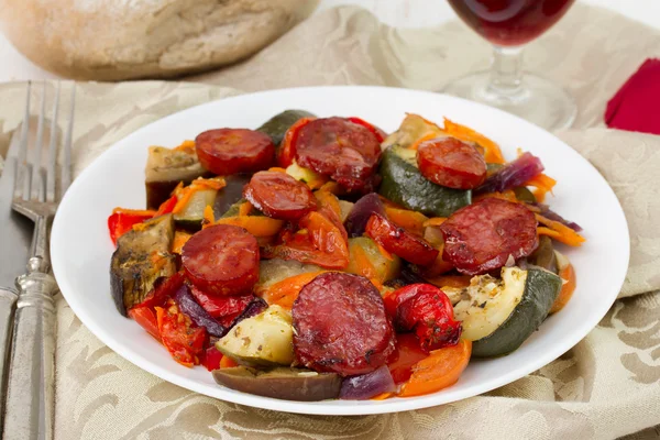 Salsichas fritas com legumes no prato — Fotografia de Stock