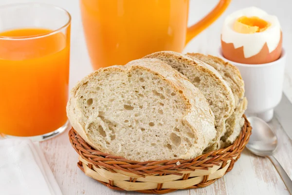 Bröd med glas juice, cup och ägg — Stockfoto