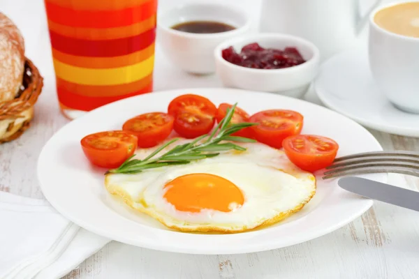 Oeuf frit avec cerise tomate sur la plaque blanche — Photo