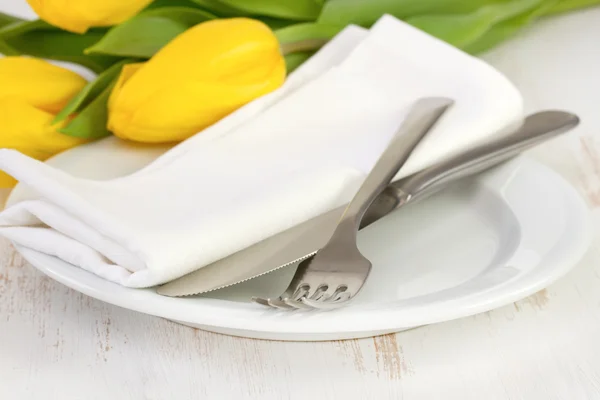 Plate with fork, knife, napkin and yellow tulips — Stock Photo, Image