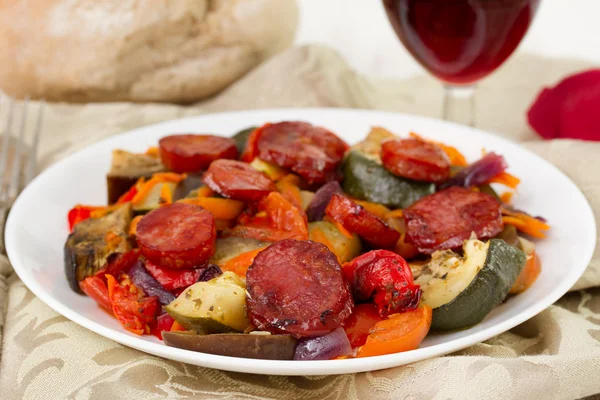 Vegetables with chorizo on the white plate — Stock Photo, Image