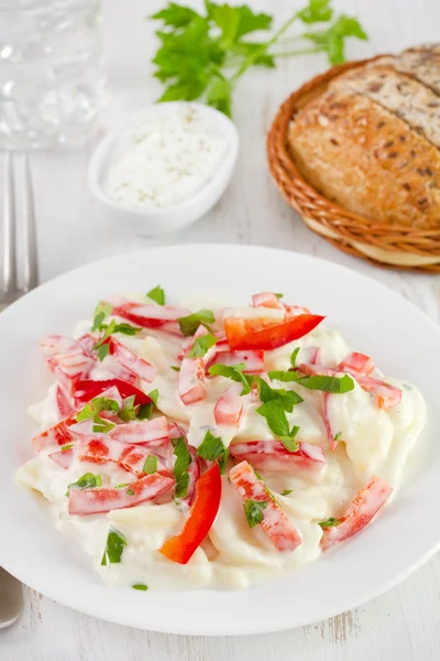 Salat med kartoffel, peber, mayonnaise på pladen - Stock-foto