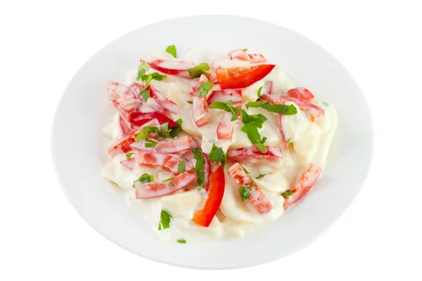Salat med kartoffel, peber, mayonnaise på pladen - Stock-foto