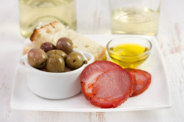 Saucisse coupée aux olives, huile d'olive et pain — Photo