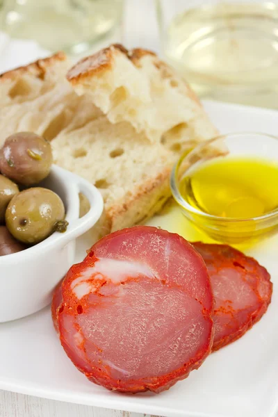 Saucisse coupée aux olives, huile d'olive et pain — Photo