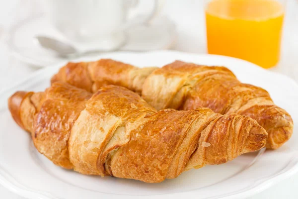 Croissant mit Tee und Orangensaft — Stockfoto