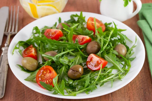 Rucola med gröna oliver och tomat körsbär — Stockfoto