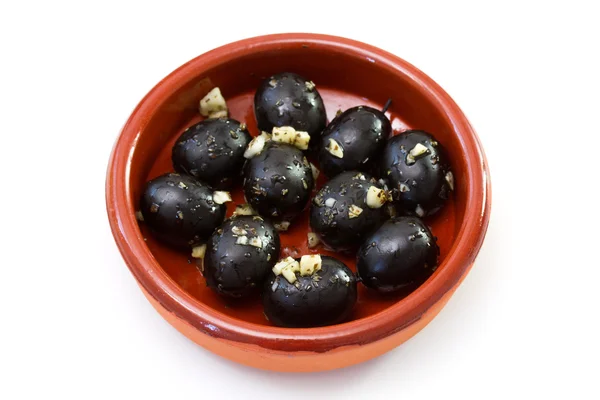 Olives noires à l'ail dans un plat en céramique — Photo