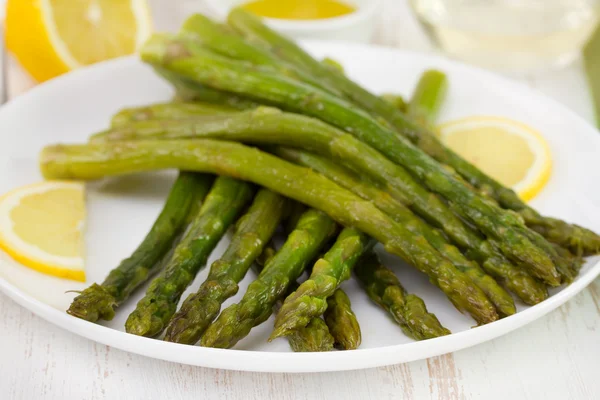 Asparagus with lemon on white plate — Stock Photo, Image