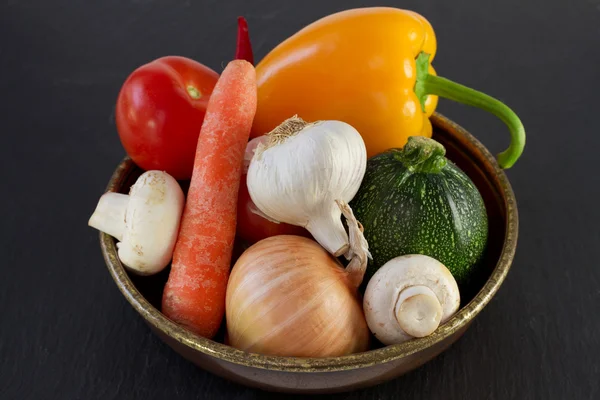 Vegetables in the old dish on dark background — Stock Photo, Image