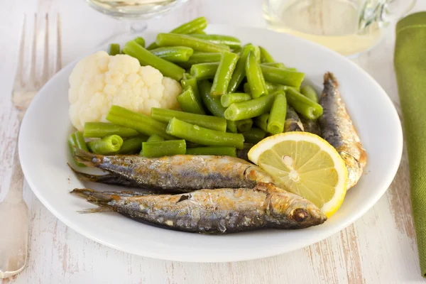 Pesce con verdure sul piatto bianco — Foto Stock