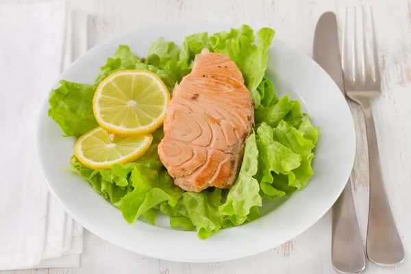 Fried salmon on lettuce with lemon — Stock Photo, Image