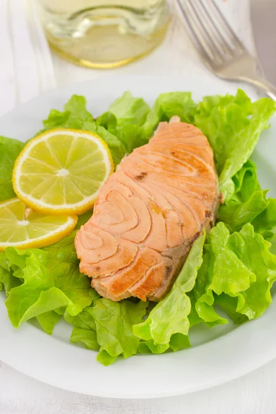 Salmon with lemon on lettuce with glass of wine — Stock Photo, Image