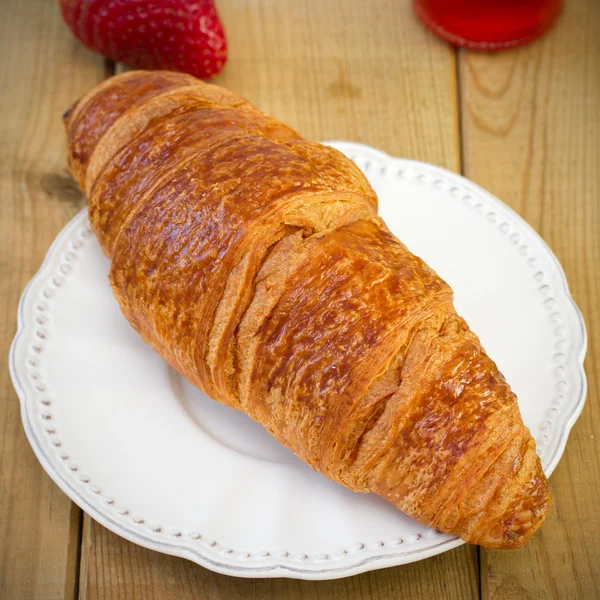 Croissant auf dem Teller mit Erdbeere — Stockfoto