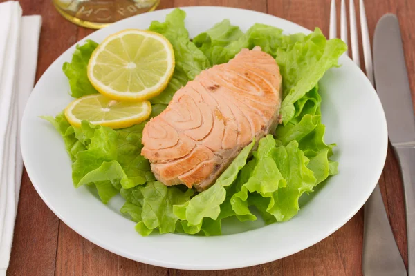 Salmon on lettuce with lemon — Stock Photo, Image