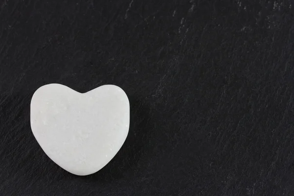 Coeur en pierre blanche sur fond sombre — Photo