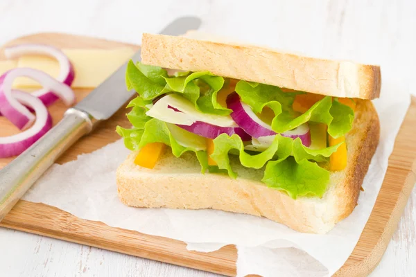 Sanduíche com queijo sobre papel — Fotografia de Stock