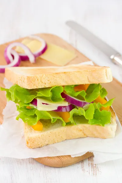 Smörgås med ost på papper — Stockfoto