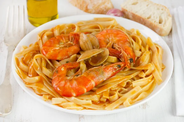 Спагетти с морепродуктами на белой тарелке — стоковое фото