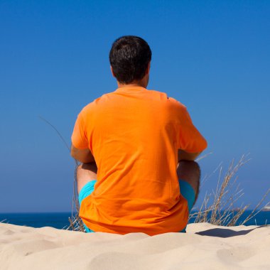 kum üzerine oturan adam