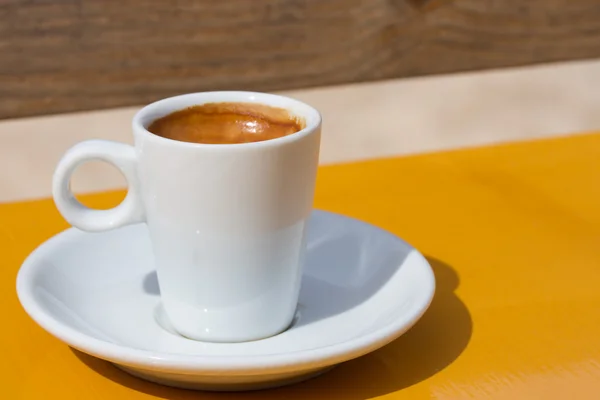 Чашка кави на жовтому столі — стокове фото
