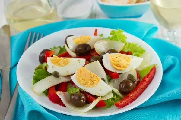 Salad on white plate and glass of white wine — Stock Photo, Image