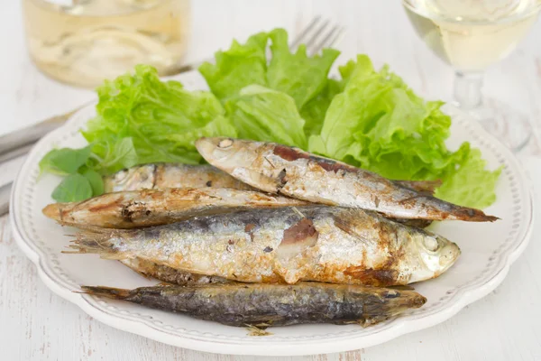 Sardines with salad on the white plate — Stock Photo, Image