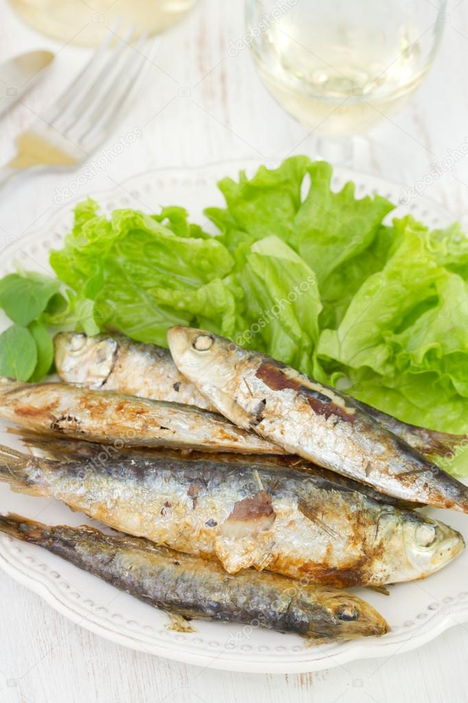 sardines with salad on the white plate