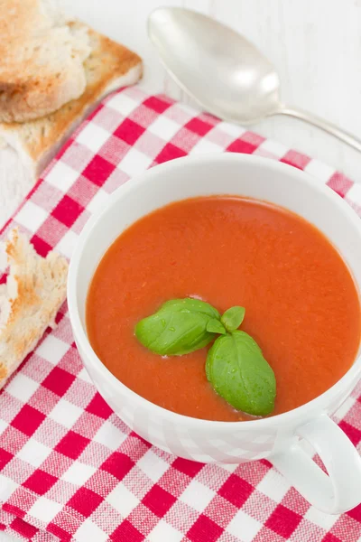 Tomatensuppe mit Basilikum in weißer Schüssel — Stockfoto