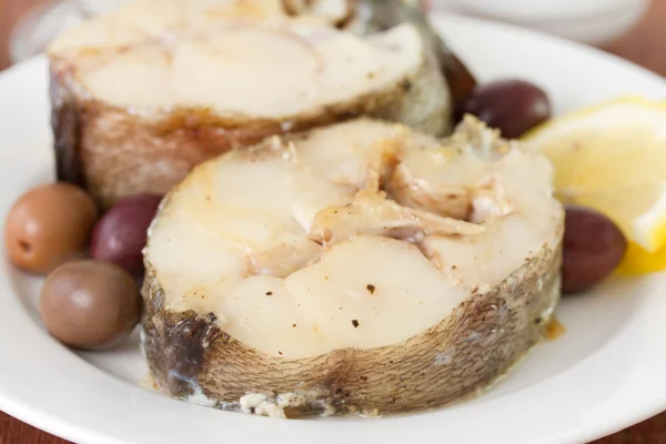 Boiled fish with olives and lemon — Stock Photo, Image