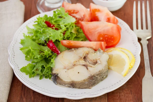 Peixe cozido com legumes no prato — Fotografia de Stock