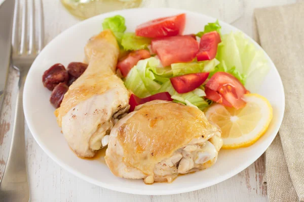Жареная курица с салатом на тарелке — стоковое фото